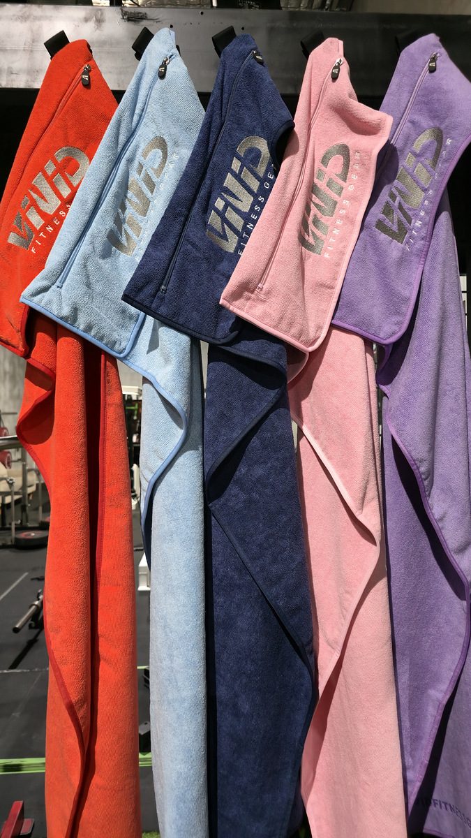 VIVID hooded gym towels in grey, navy, purple, light pink, red and light blue hanging side by side